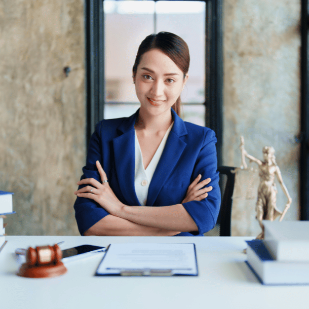 Young female lawyer sitting at her desk smiling into the camera