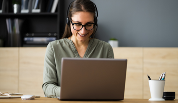 Woman with headphones in front of laptop