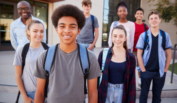 A diverse group of students standing outside the school building