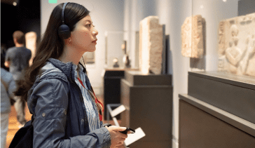 Woman in museum using headphones